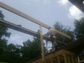 Carpenter setting a ridge beam over a new addition frame — Ice Dam Removal by Roofing Brothers in Choctaw