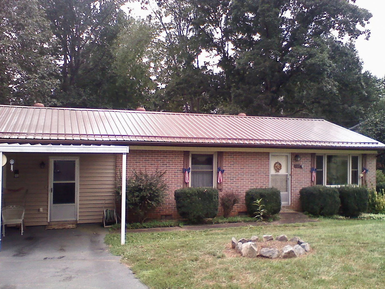 Bronze metal roof and carport on a brick ranch home — Roof Repair work by our crew in Choctaw