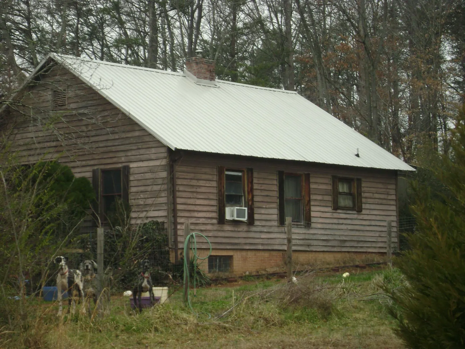 White metal roof on an old wood sided farmhouse, from a Metal Roof Installation job in Choctaw